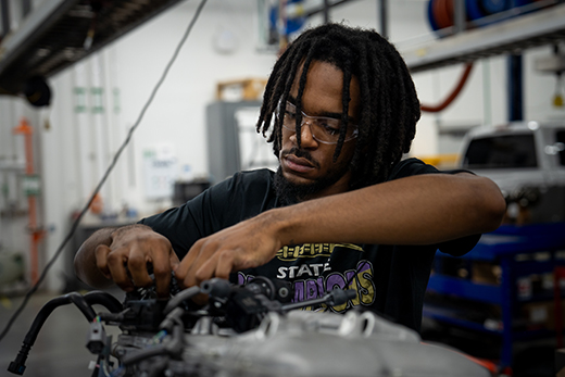 Tyler Brown works on vehicle parts in the automotive shop.