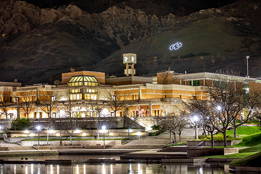 Campus at night, overlooked by an electric W on the mountainside