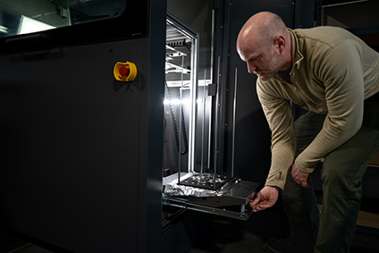 Devin Young operates a 3D printer at Weber State University's MARS Center