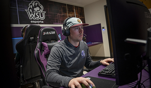 Assistant professor Bryan Dowdell sits in front of a computer in the new esports lab at Weber State.