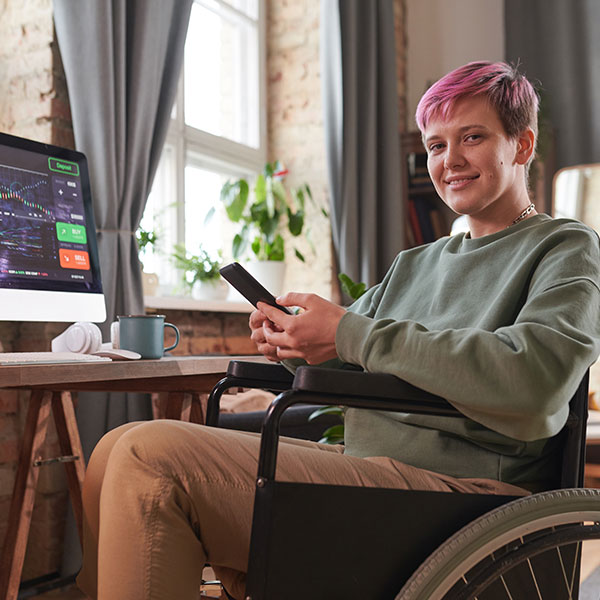 person in wheelchair next to computer