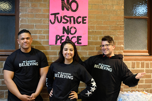  students posing with we tart by believing shirts
